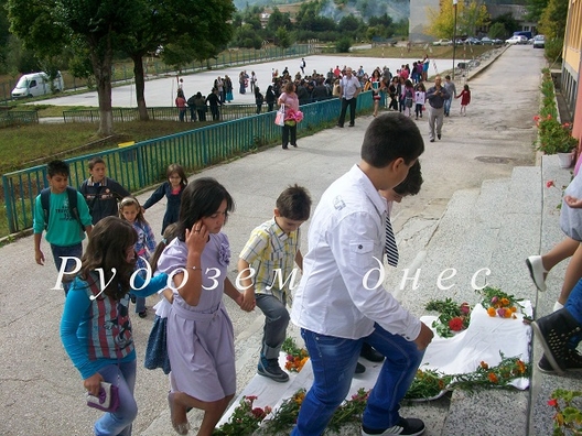 петокласниците водят за ръка най-малките си съученици към дома на знанието.